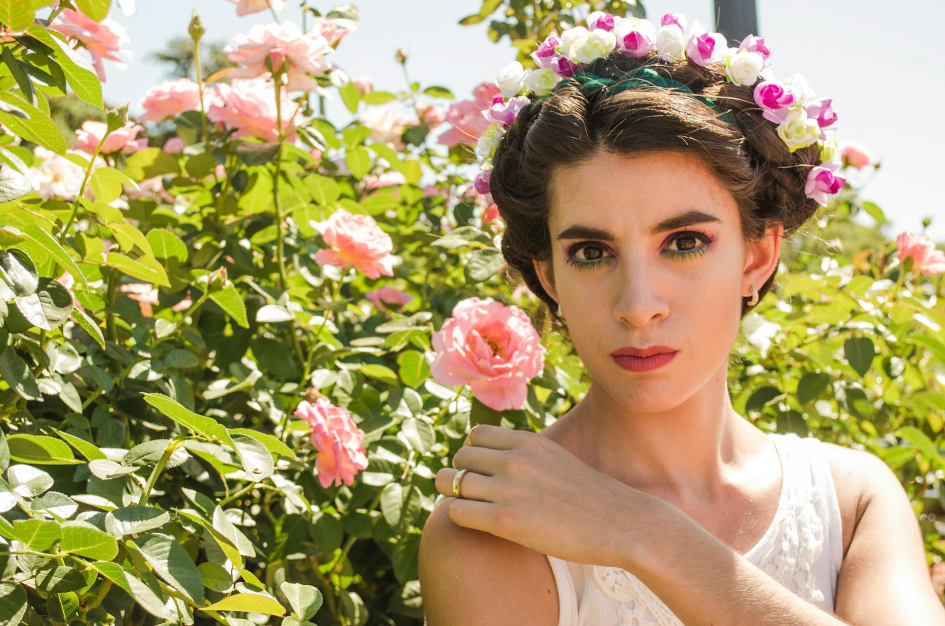 Eine fröhliche Gärtnerin pflanzt Blumen in ihrem persönlich gestalteten Schweizer Garten, umgeben von grünen Pflanzen und einer gemütlichen Sitzgelegenheit.