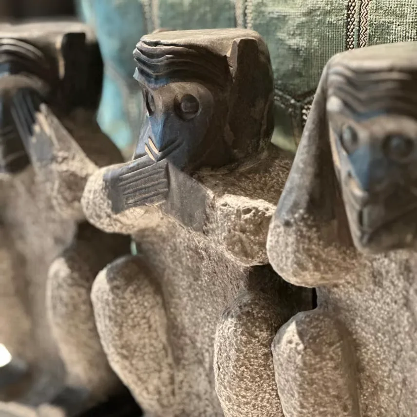 Row of carved stone monkey figurines displayed as decorative objects on a shelf.