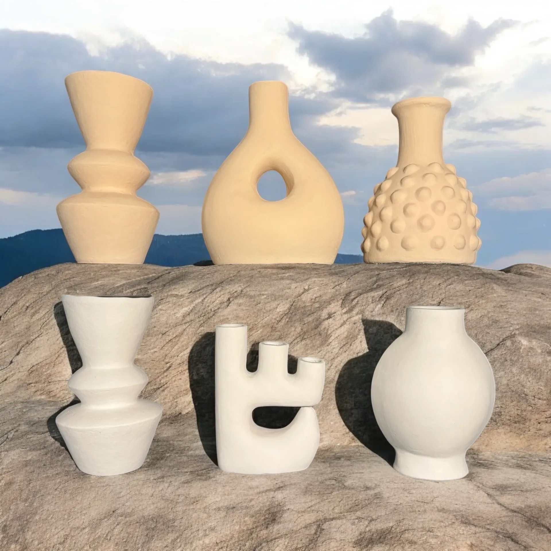 Collection of sculptural ceramic vases in cream and white displayed outdoors, perfectly representing ALPA Concept's curated aesthetic and design philosophy.