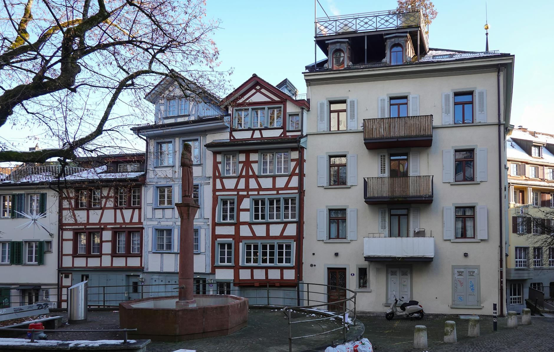 Ein heller Schweizer Wohnraum mit harmonischer Farbgestaltung: weisse Wände, Holzböden und farbige Akzente durch Möbel und Dekoration, die Gemütlichkeit und Persönlichkeit ausstrahlen.