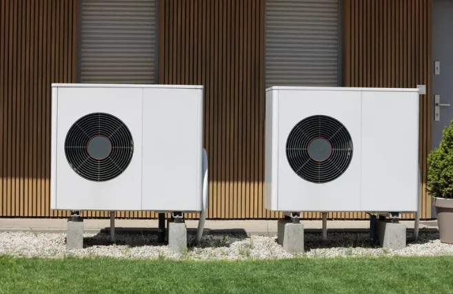 Eine moderne Hybrid-Wärmepumpe installiert an der Aussenwand eines traditionellen Schweizer Chalets im Winter, symbolisiert die Verbindung von effizienter Technologie mit Schweizer Baukultur.
