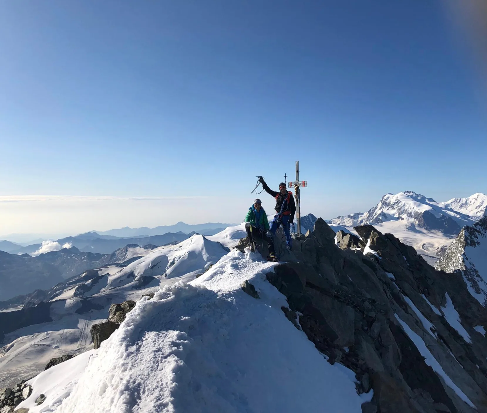 Two mountaineers celebrating a summit conquest, symbolizing Oliver Mayer's 'Gipfelstürmer' spirit and determination mentioned in the article.