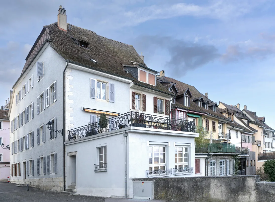 Ein Schweizer Einfamilienhaus im Bau mit sichtbaren, aber subtilen Baumängeln, während ein Fachmann die Konstruktion überprüft.
