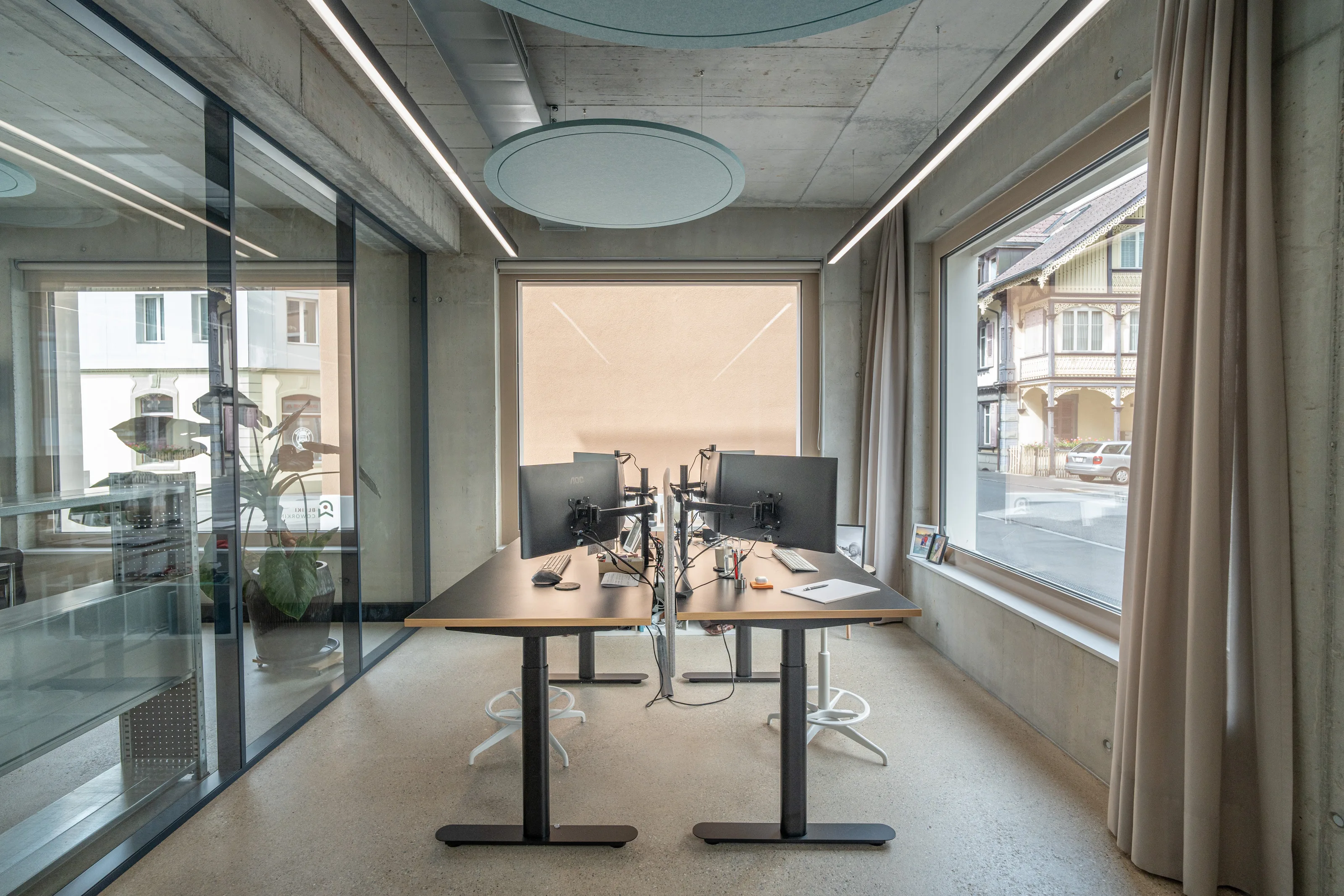 Two NUVO AG founders working side by side at their modern Interlaken office, conveying the collaborative expertise behind their Bauökonomie firm.